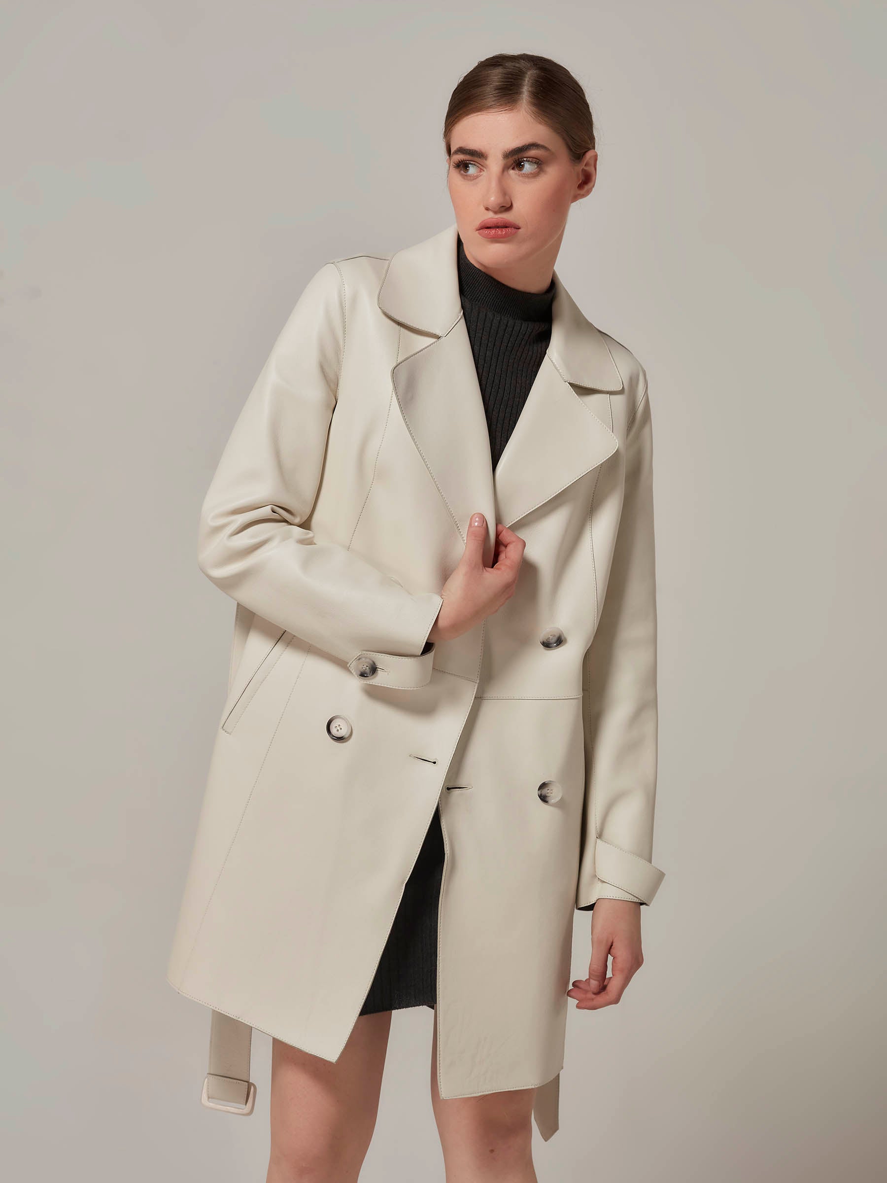 woman posing in white leather trench coat front view