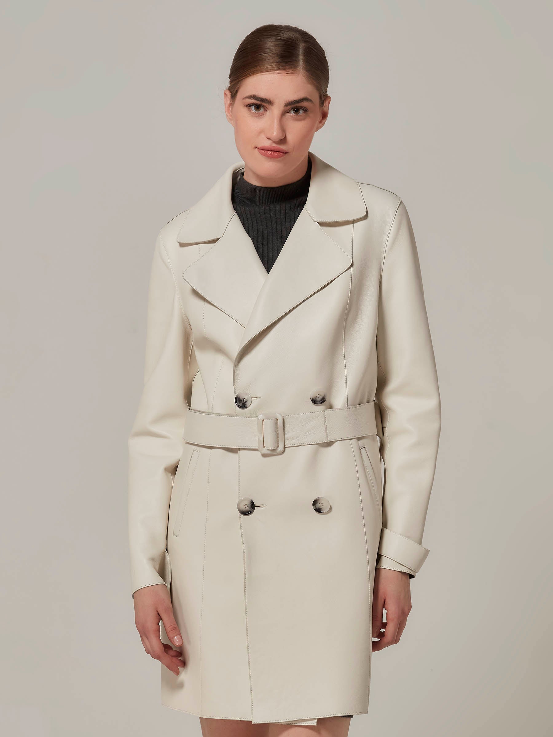 woman posing in white leather trench coat front view