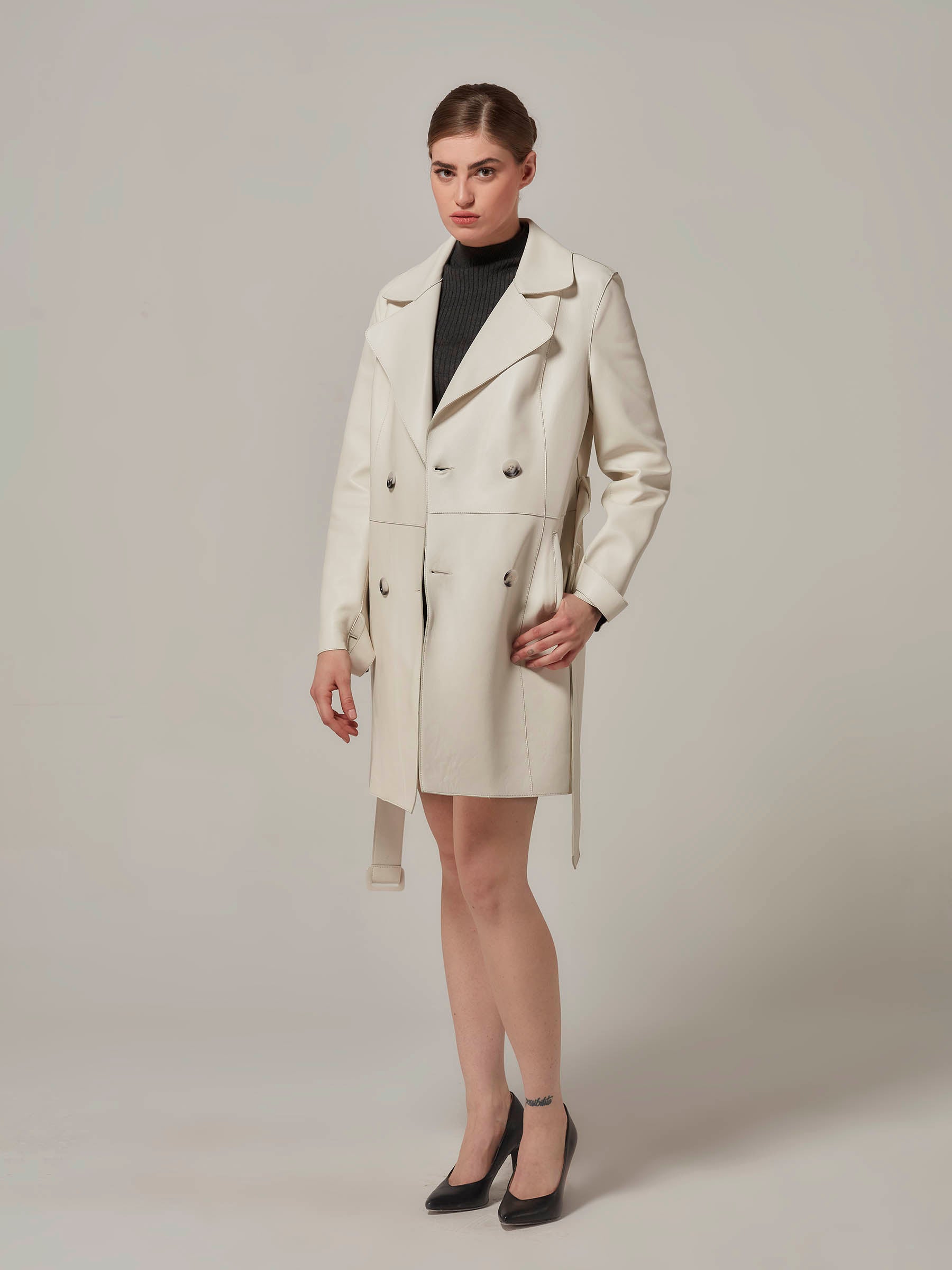 woman posing in white leather trench coat front view