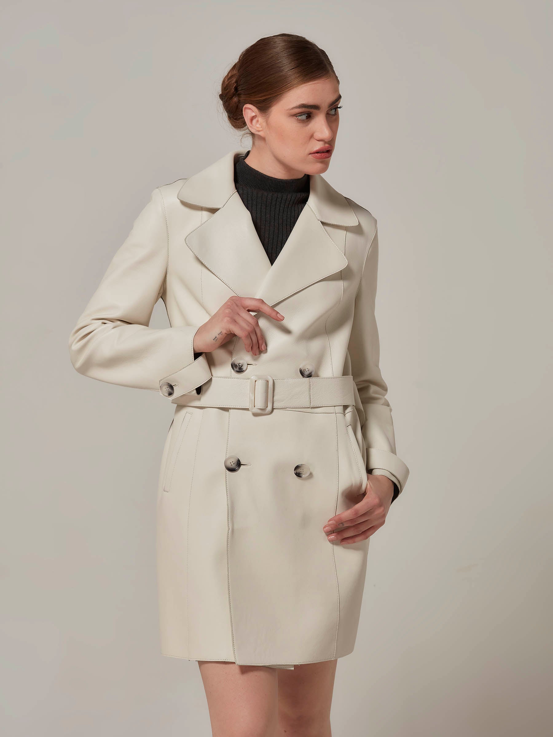 woman posing in white leather trench coat  front view