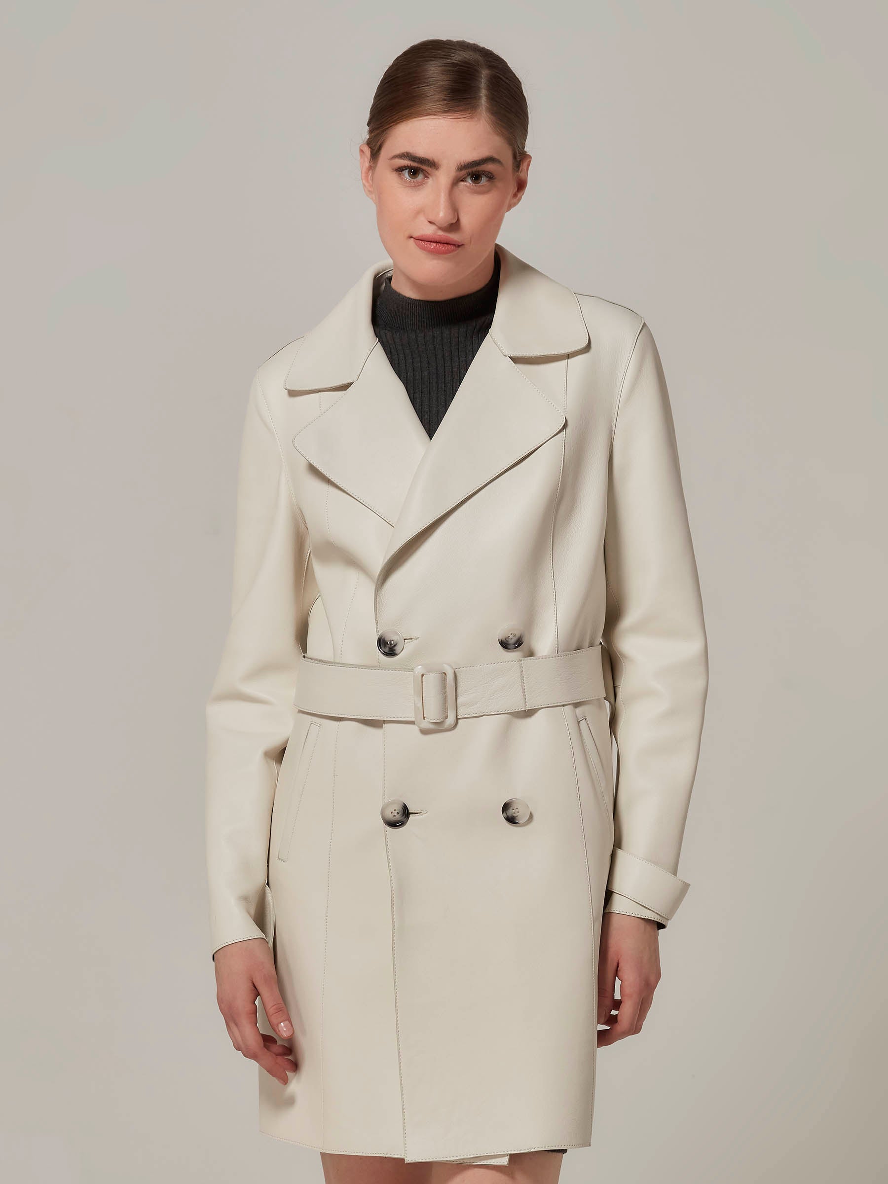 woman posing in white leather trench coat  front view