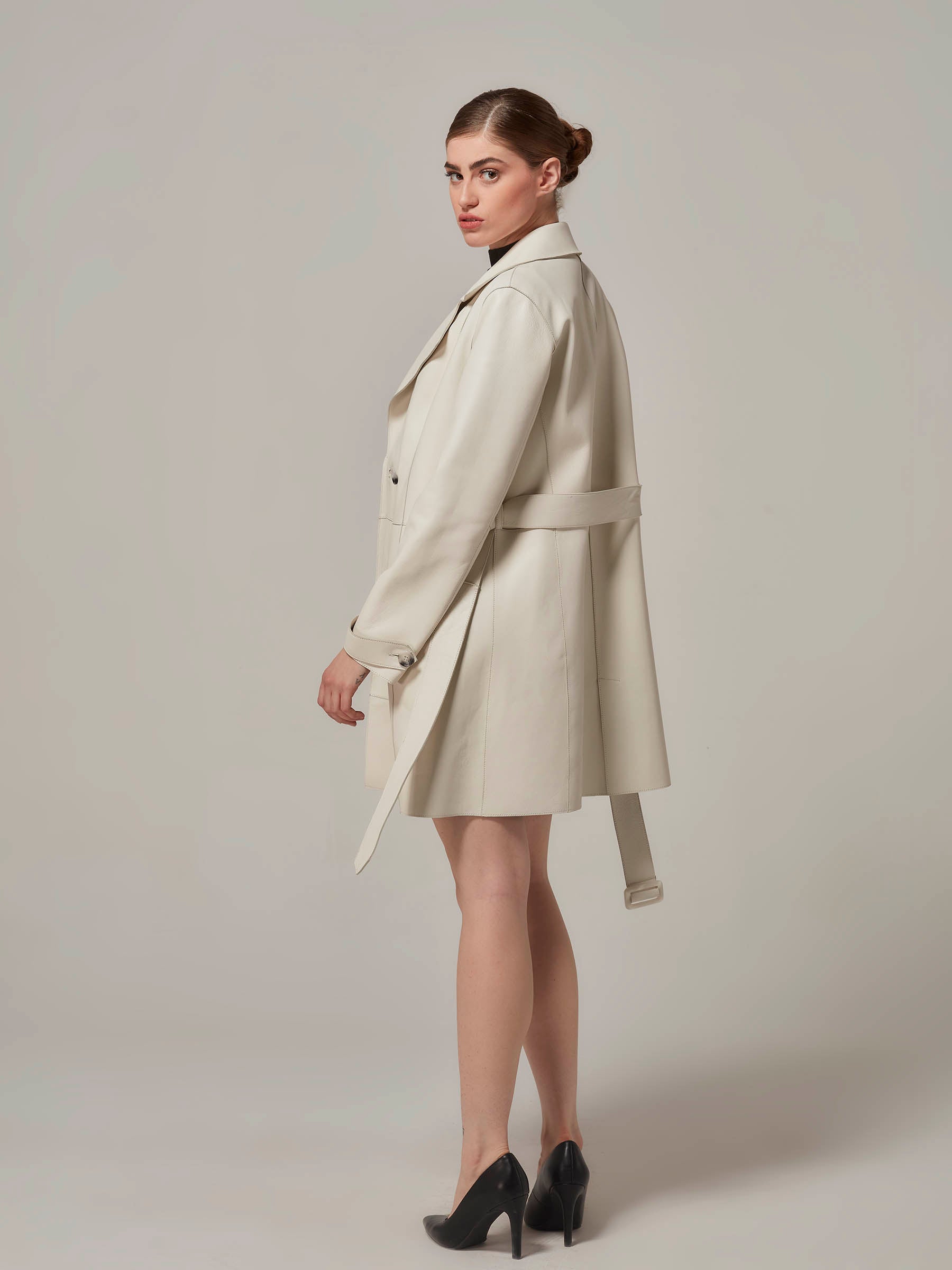 white leather minimalist trench coat woman standing full side